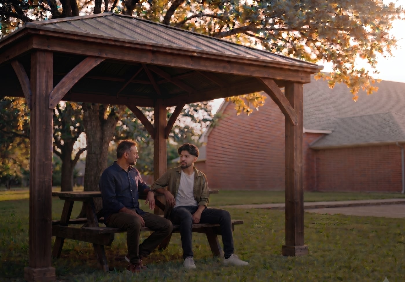 Two community members talking under the pavilion on the ICS grounds at golden hour