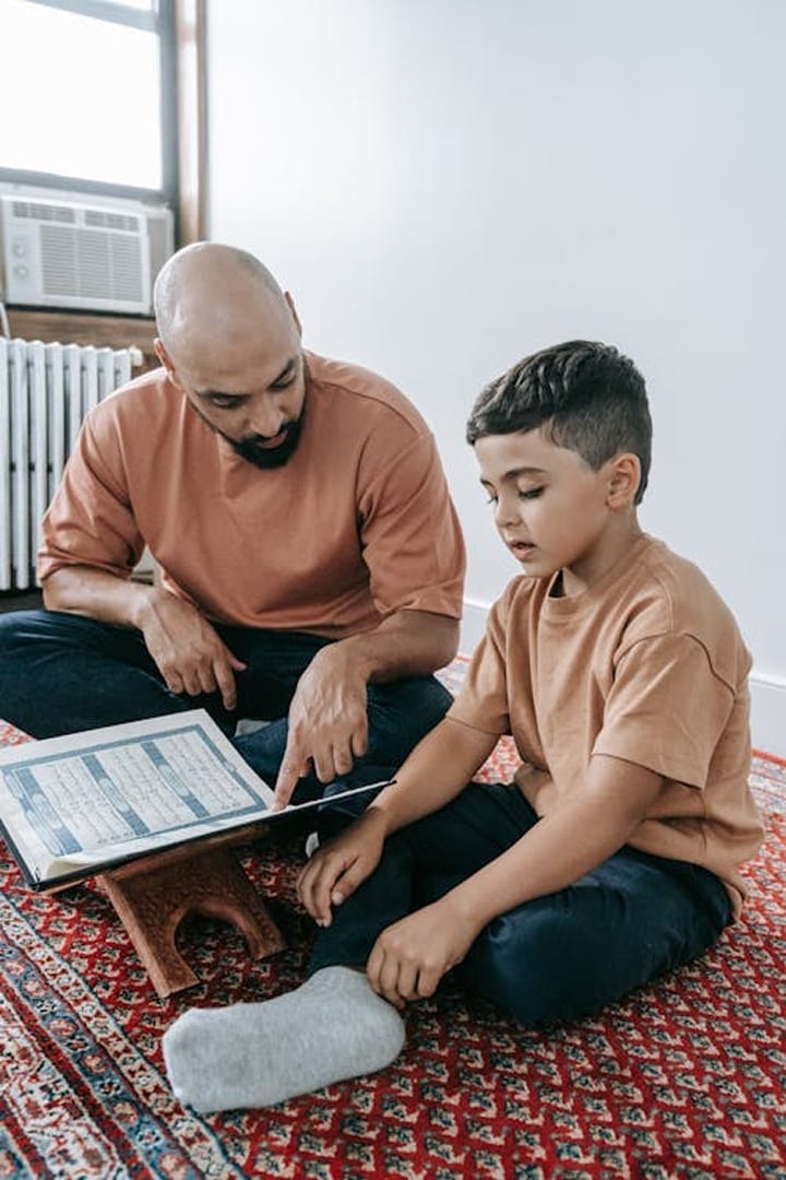 A parent and child reviewing schoolwork together on a laptop at home